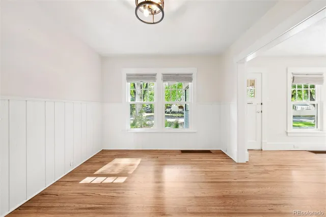 a view of empty room with wooden floor fireplace and a window