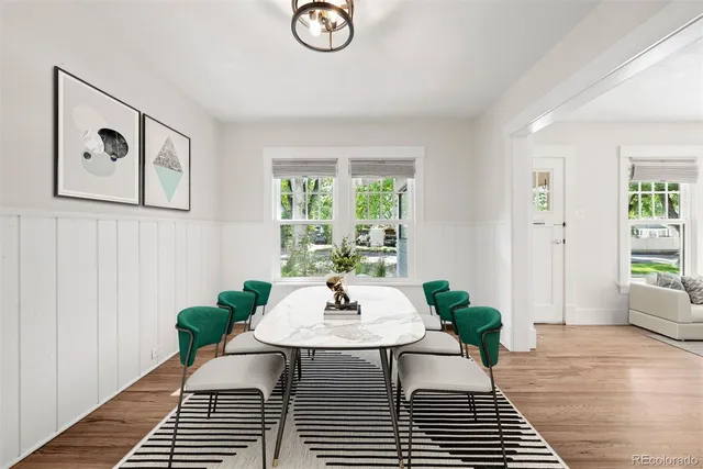 a kitchen with stainless steel appliances granite countertop a table chairs in it and wooden floors