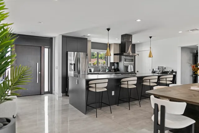 a kitchen with stainless steel appliances kitchen island granite countertop a refrigerator and a stove top oven