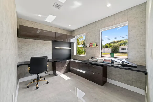 a view of a workspace with furniture and a window