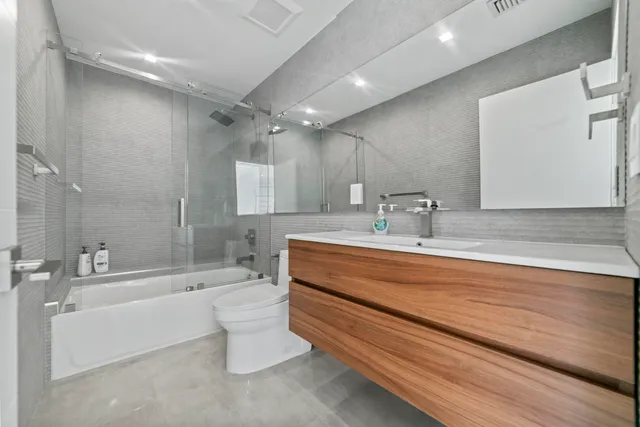 a bathroom with a bathtub shower sink vanity and toilet