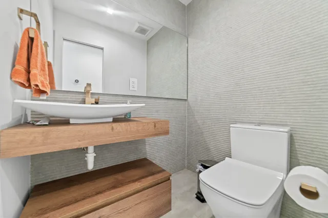 a bathroom with a toilet sink and mirror