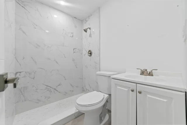 a bathroom with a sink a toilet and shower