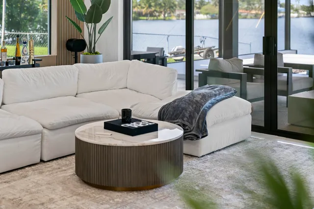 a living room with couches and a fireplace with wooden floor