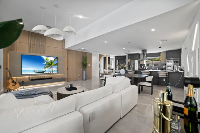 a living room with furniture kitchen view and a flat screen tv