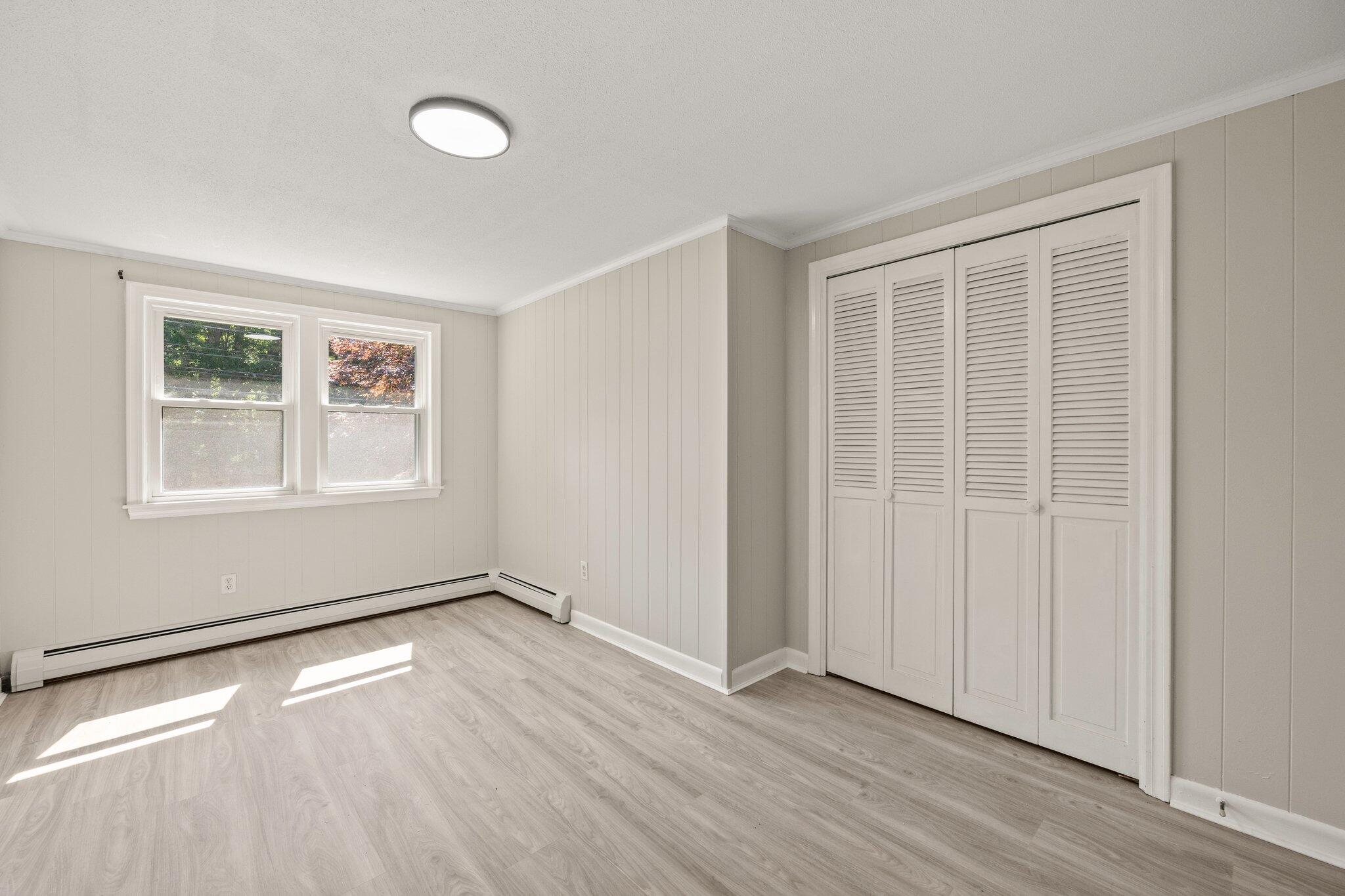 87 Fuller Road Centerville, MA 02632 - Photo 12 of 33 an empty room with wooden floor and windows