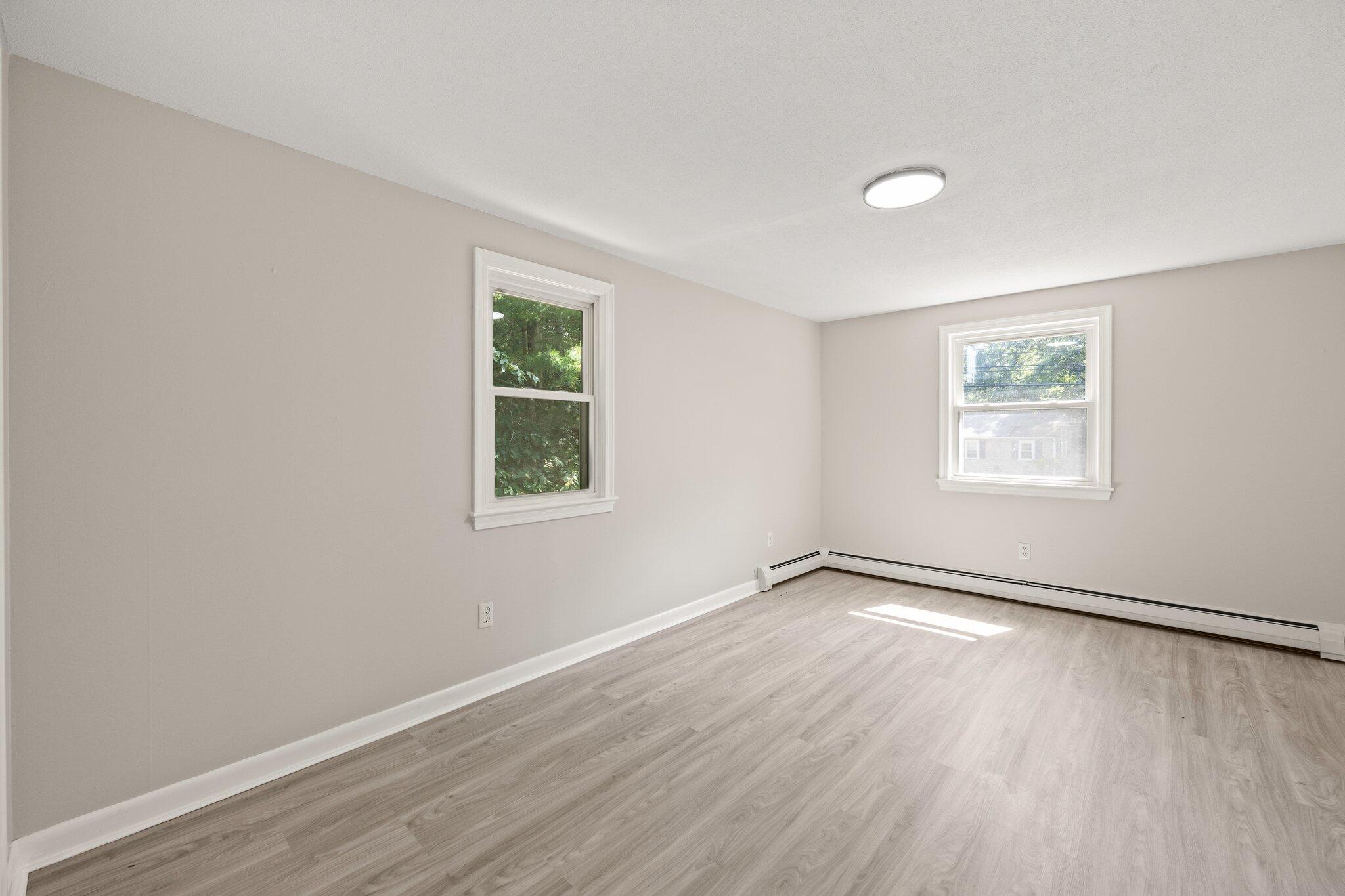 87 Fuller Road Centerville, MA 02632 - Photo 15 of 33 an empty room with wooden floor and windows