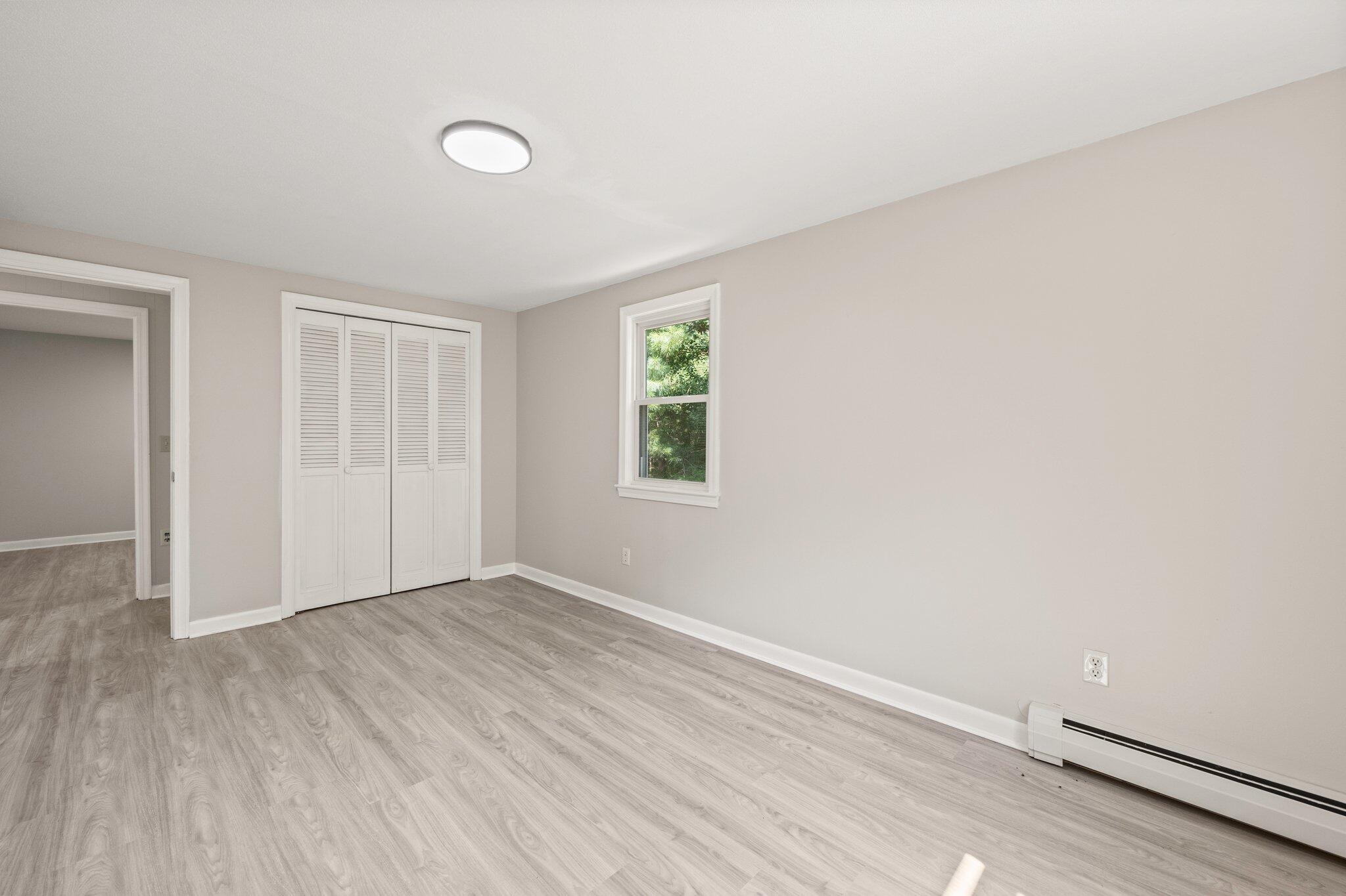 87 Fuller Road Centerville, MA 02632 - Photo 16 of 33 an empty room with wooden floor and windows