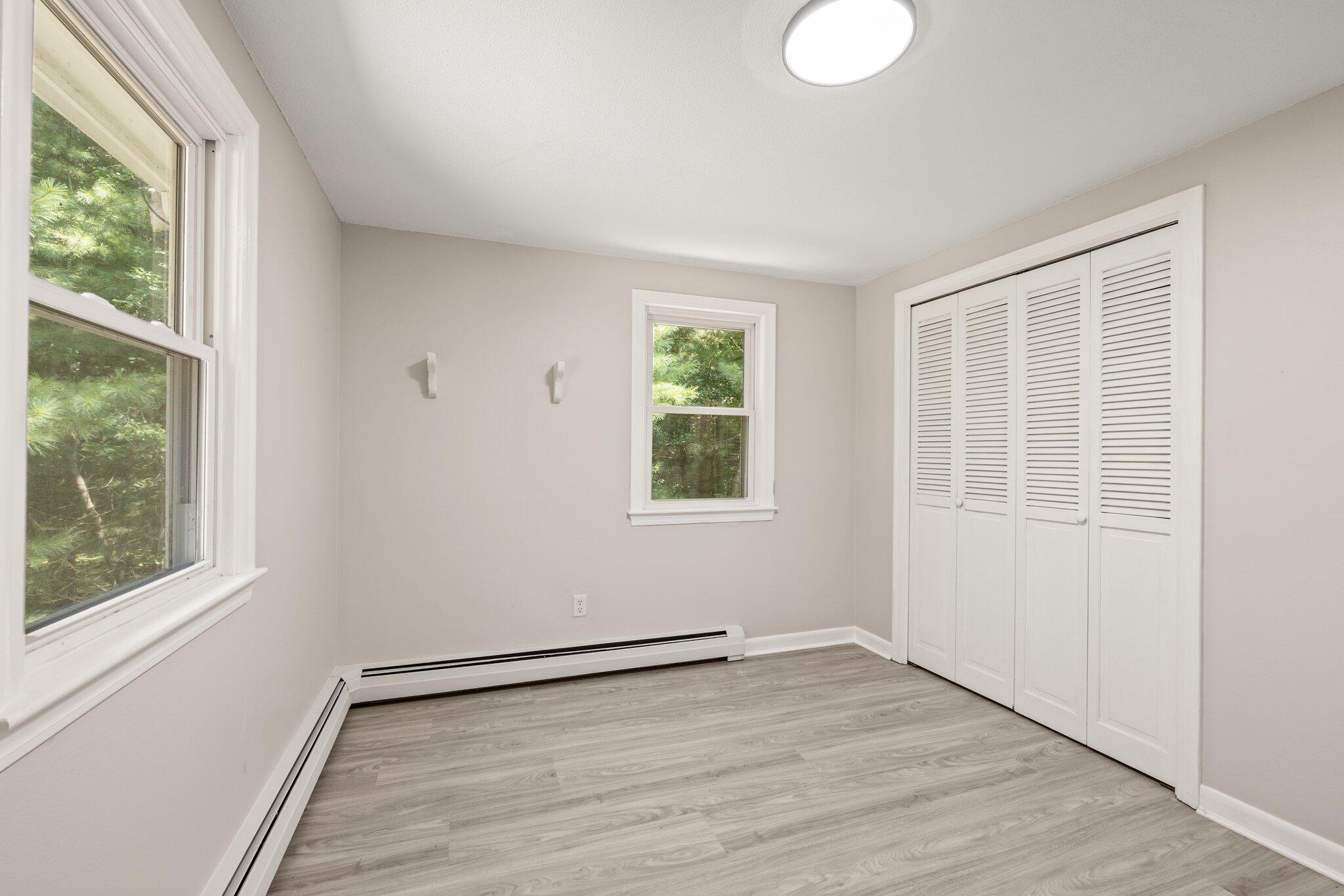 87 Fuller Road Centerville, MA 02632 - Photo 18 of 33 an empty room with wooden floor and windows