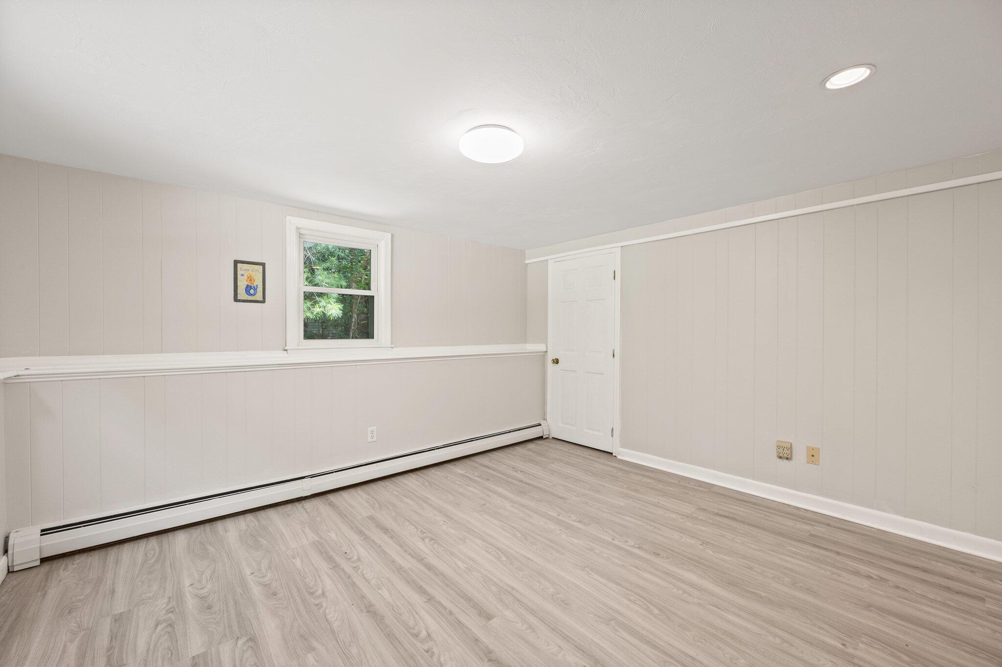 87 Fuller Road Centerville, MA 02632 - Photo 24 of 33 an empty room with wooden floor and windows
