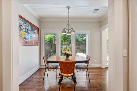 a dining room with furniture a chandelier and wooden floor