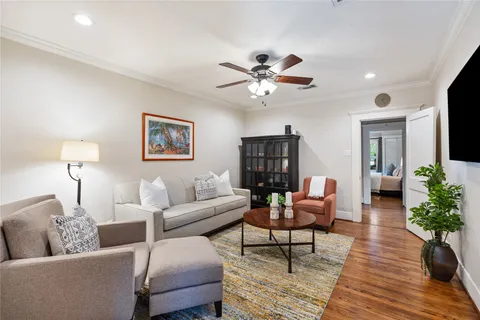 a living room with furniture a flat screen tv and a potted plant
