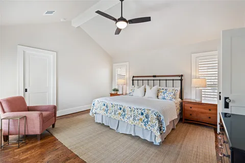 a bedroom with a bed a couch and a chandelier