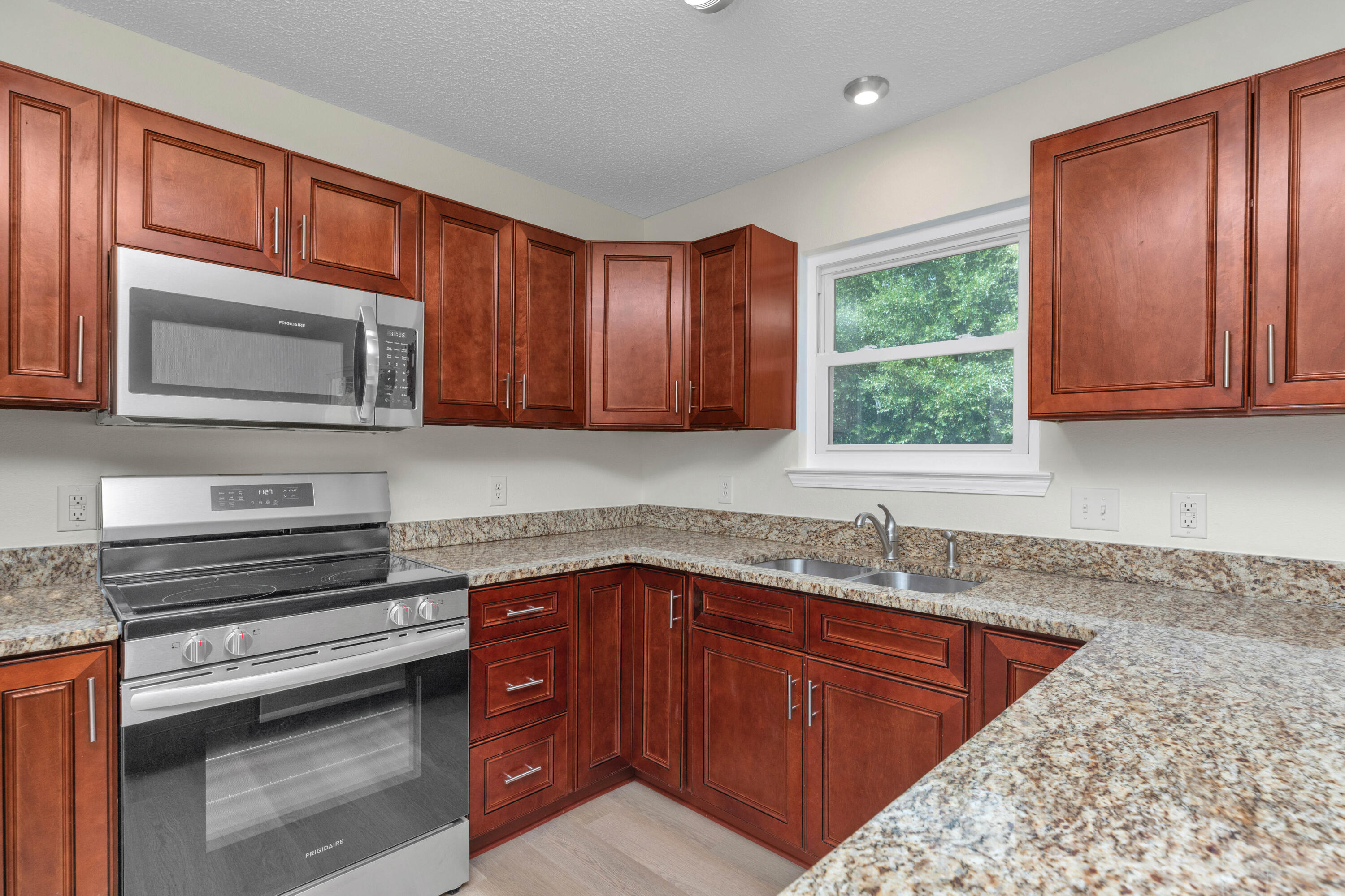 203 Riverchase Boulevard Crestview, FL 32536 - Photo 11 of 36 a kitchen with stainless steel appliances granite countertop wooden cabinets a sink and dishwasher