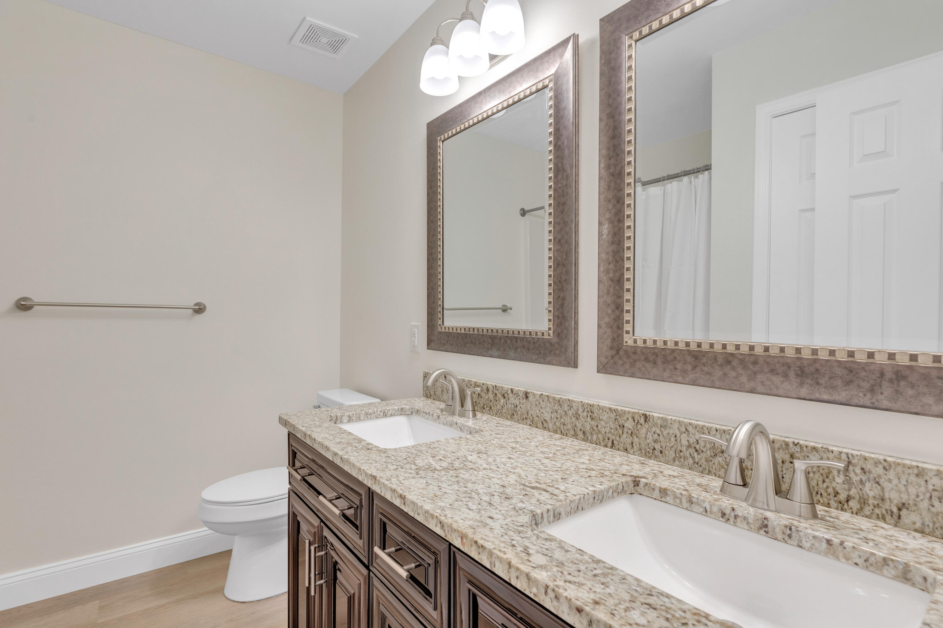 203 Riverchase Boulevard Crestview, FL 32536 - Photo 19 of 36 a bathroom with a granite countertop sink a toilet and a mirror