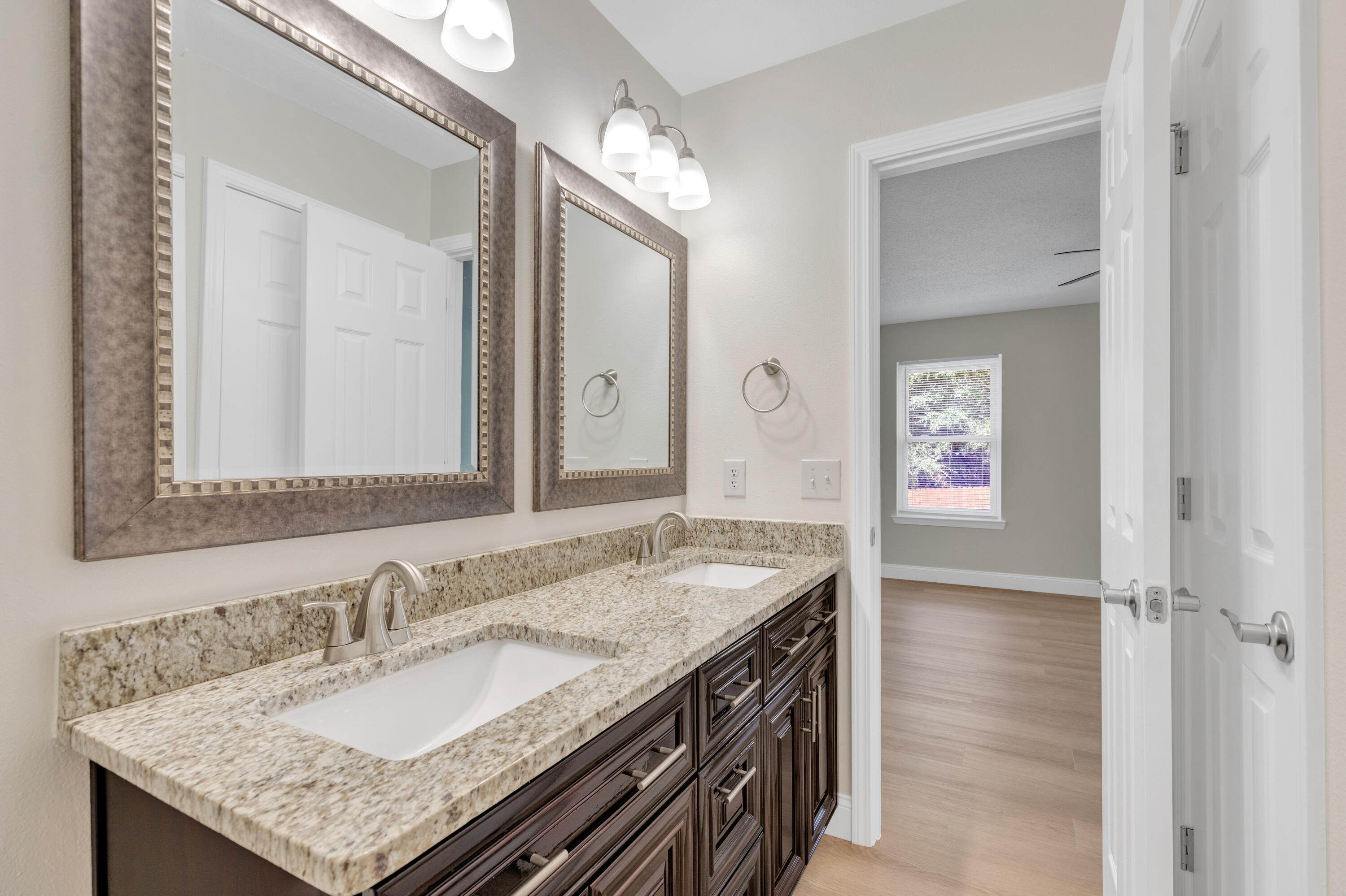 203 Riverchase Boulevard Crestview, FL 32536 - Photo 20 of 36 a bathroom with a granite countertop sink and a mirror
