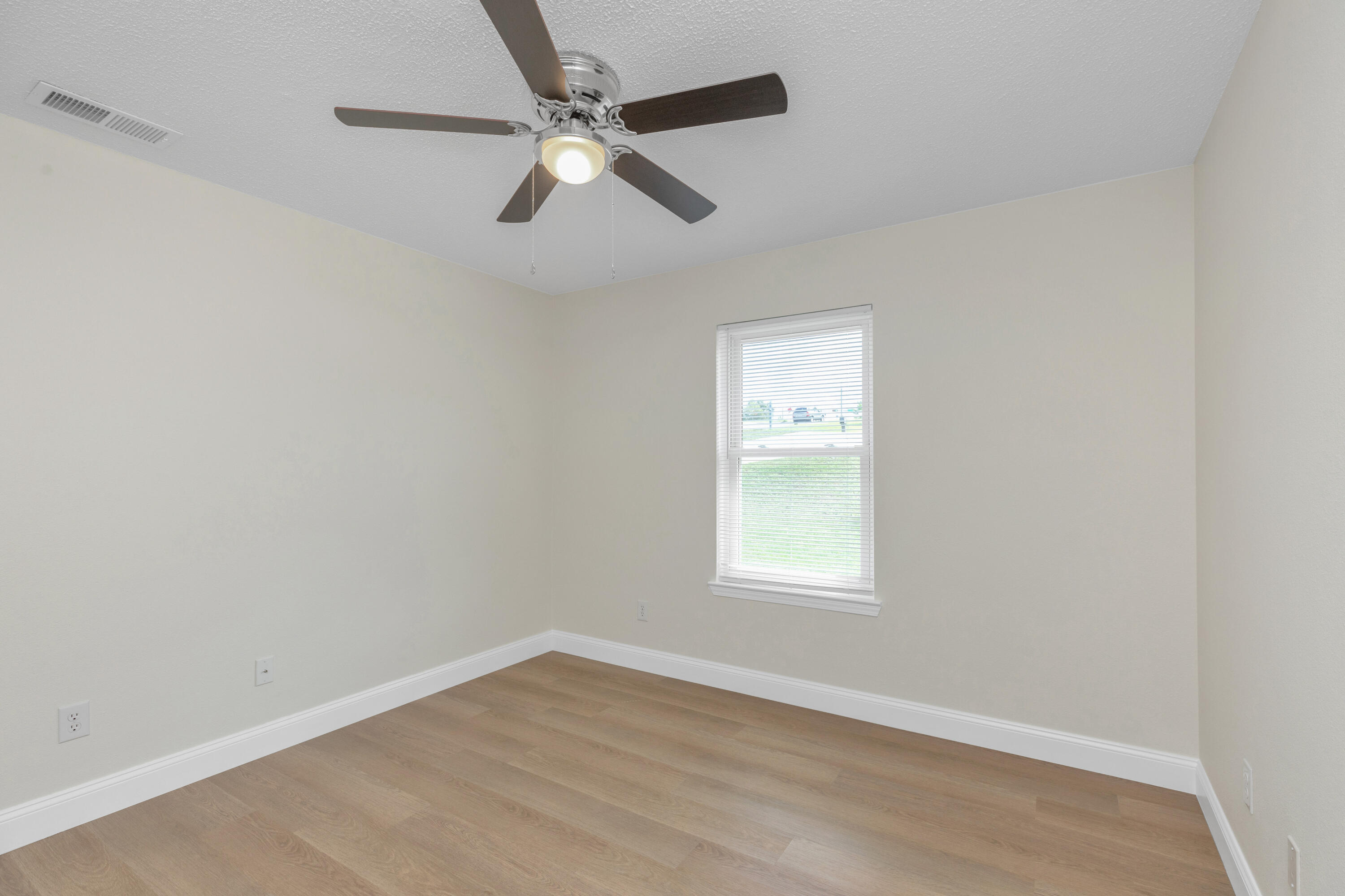 203 Riverchase Boulevard Crestview, FL 32536 - Photo 28 of 36 an empty room with wooden floor fan and windows