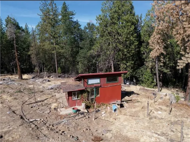 a view of backyard with wooden fence and trees