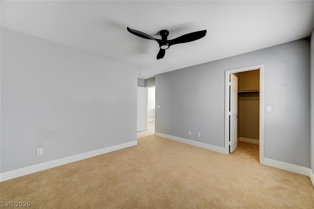 7259 Cestrum Road Las Vegas, NV 89113 - Photo 23 of 35 A spacious bedroom features plush carpeting, a modern ceiling fan, and ample closet space.