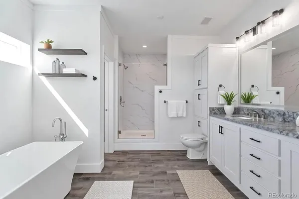 a bathroom with a double vanity sink toilet and shower