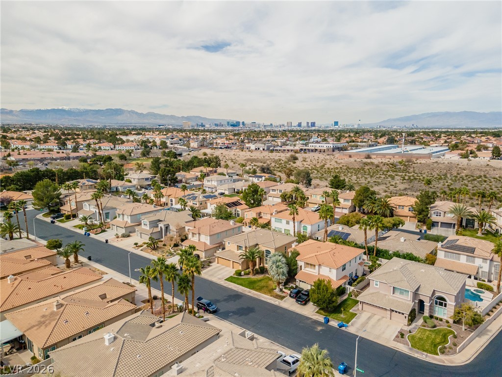 2504 Putting Green Drive Henderson, NV 89074 - Photo 52 of 56 An aerial perspective reveals a residential neighborhood with a distant cityscape and mountains.