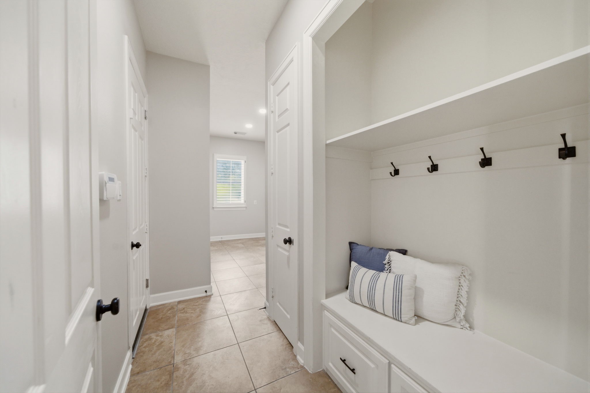 4535 Box Turtle Lane Fulshear, TX 77441 - Photo 15 of 49 Located just inside the garage is a built-in bench with storage and hooks for coats and bags.