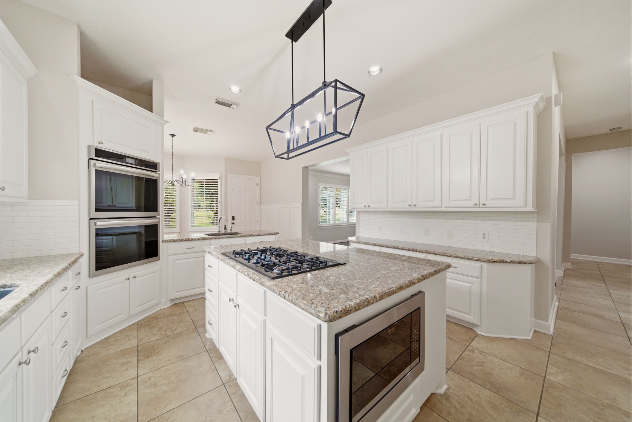 4535 Box Turtle Lane Fulshear, TX 77441 - Photo 17 of 49 This kitchen features a stylish island with an integrated microwave, offering seamless convenience for cooking and entertaining.