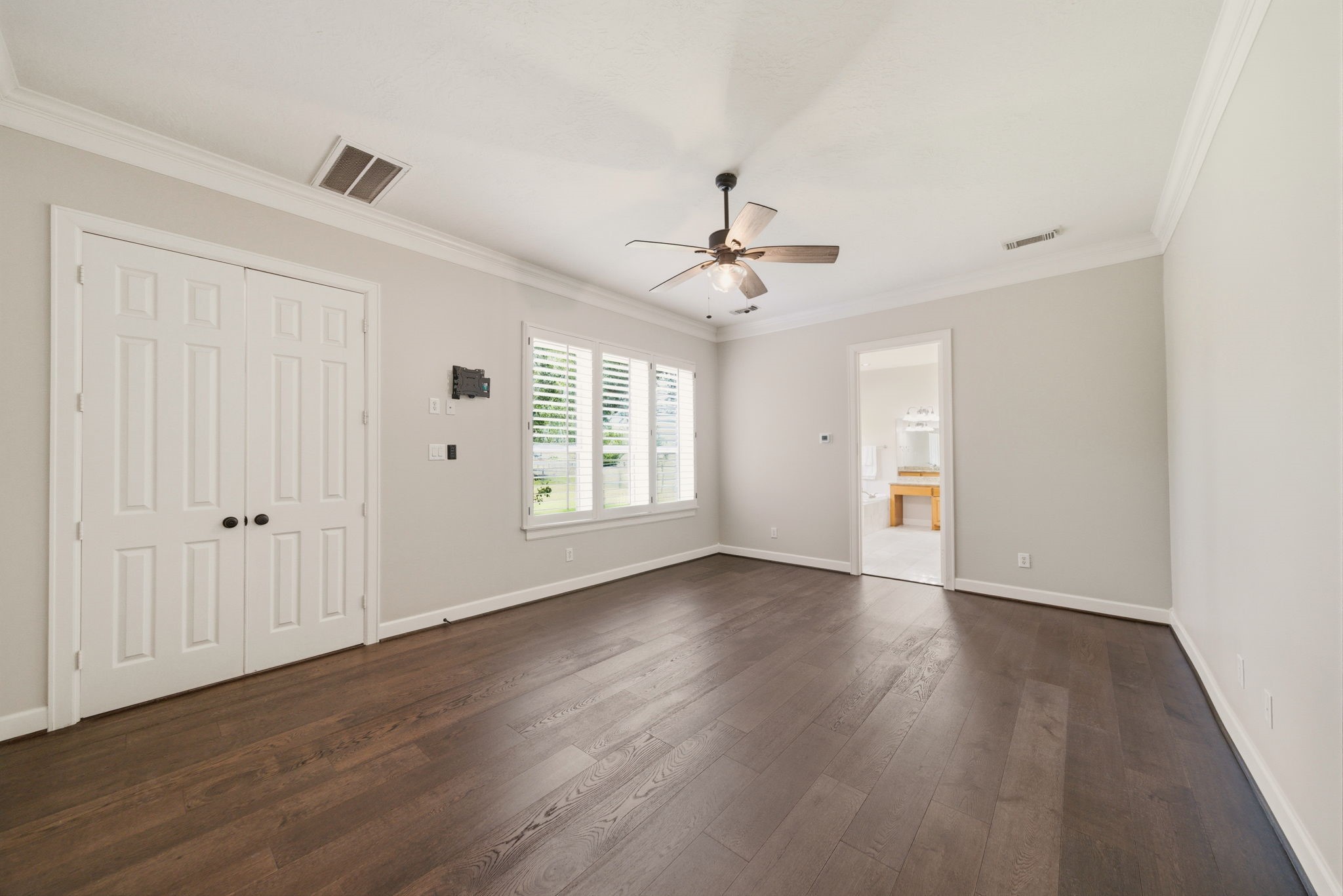 4535 Box Turtle Lane Fulshear, TX 77441 - Photo 25 of 49 The primary retreat features hard wood floors, neutral walls, and double-door access to primary bathroom and closet.