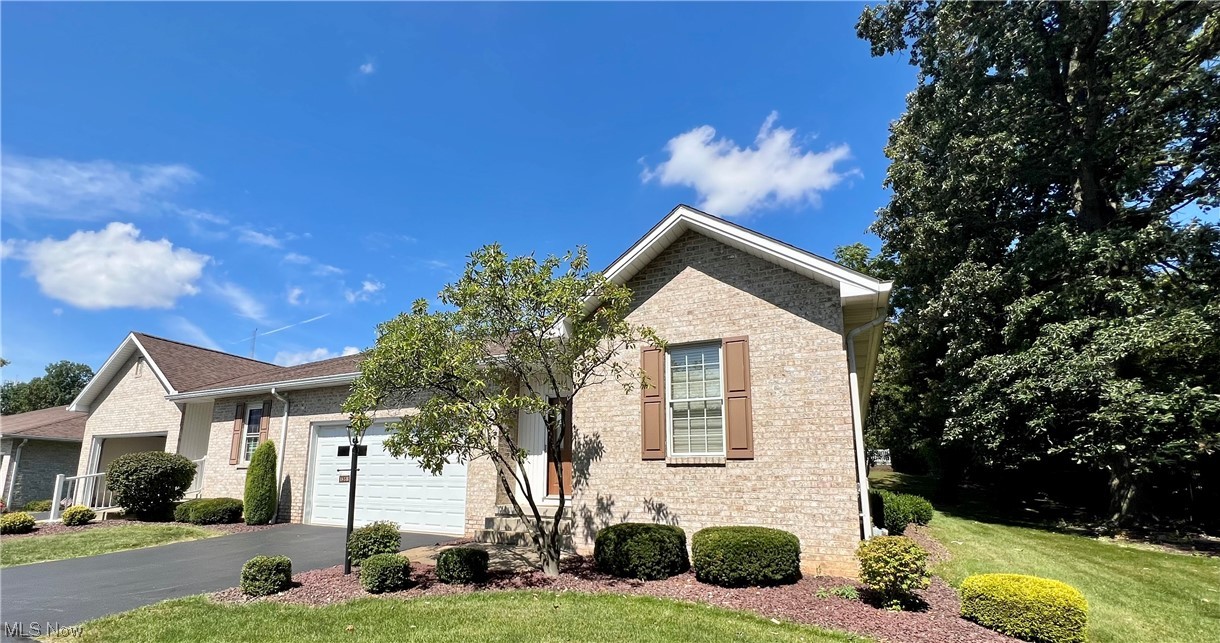 View of property featuring garage and a front yard