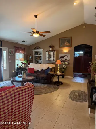 a living room with furniture a flat screen tv and a chandelier