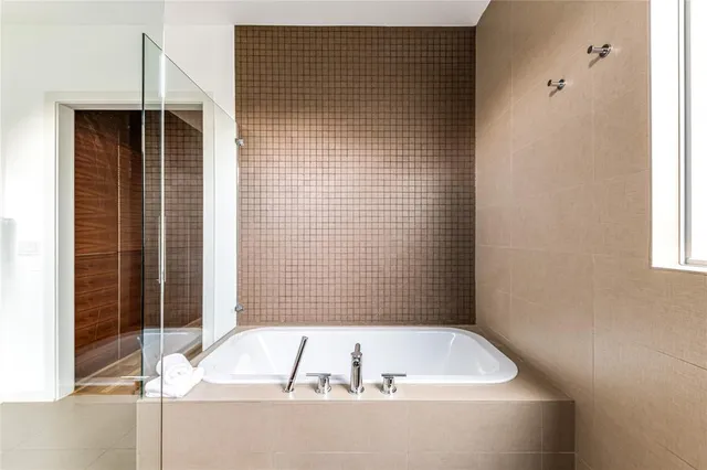 a bathroom with a tub a toilet and a shower