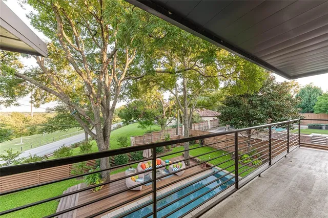 a view of trees and cars from a balcony
