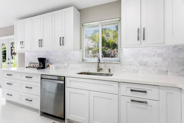 a kitchen with granite countertop white cabinets and white appliances
