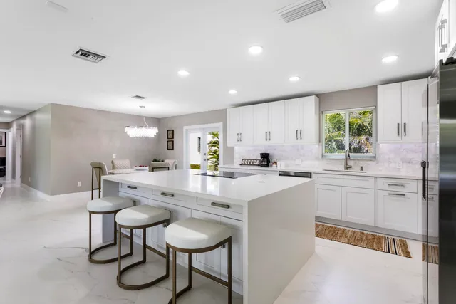 a large white kitchen with cabinets