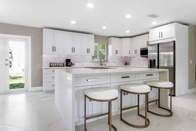 a kitchen with white cabinets and stainless steel appliances