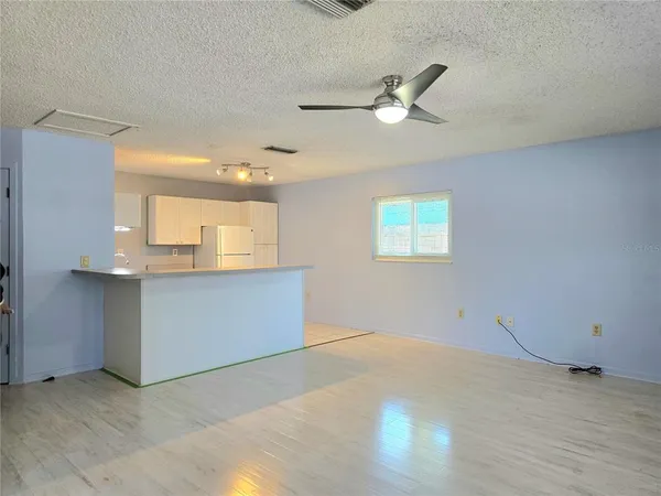 a view of a livingroom with an empty space and a ceiling fan