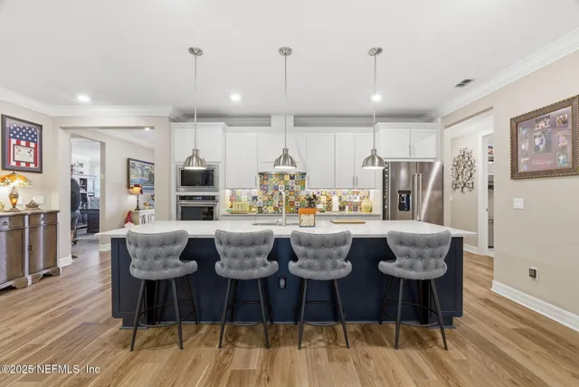 a living room with furniture kitchen and a chandelier