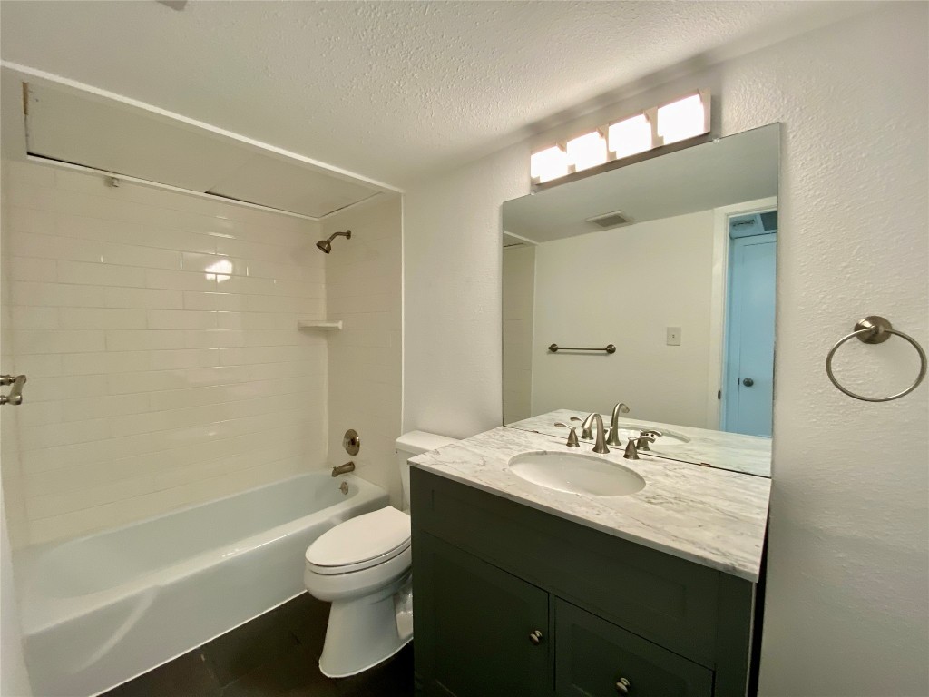 807 Blanco Street, Unit 304 Austin, TX 78703 - Photo 11 of 21 Bathroom featuring shower combination, a textured ceiling, vanity, and a textured wall