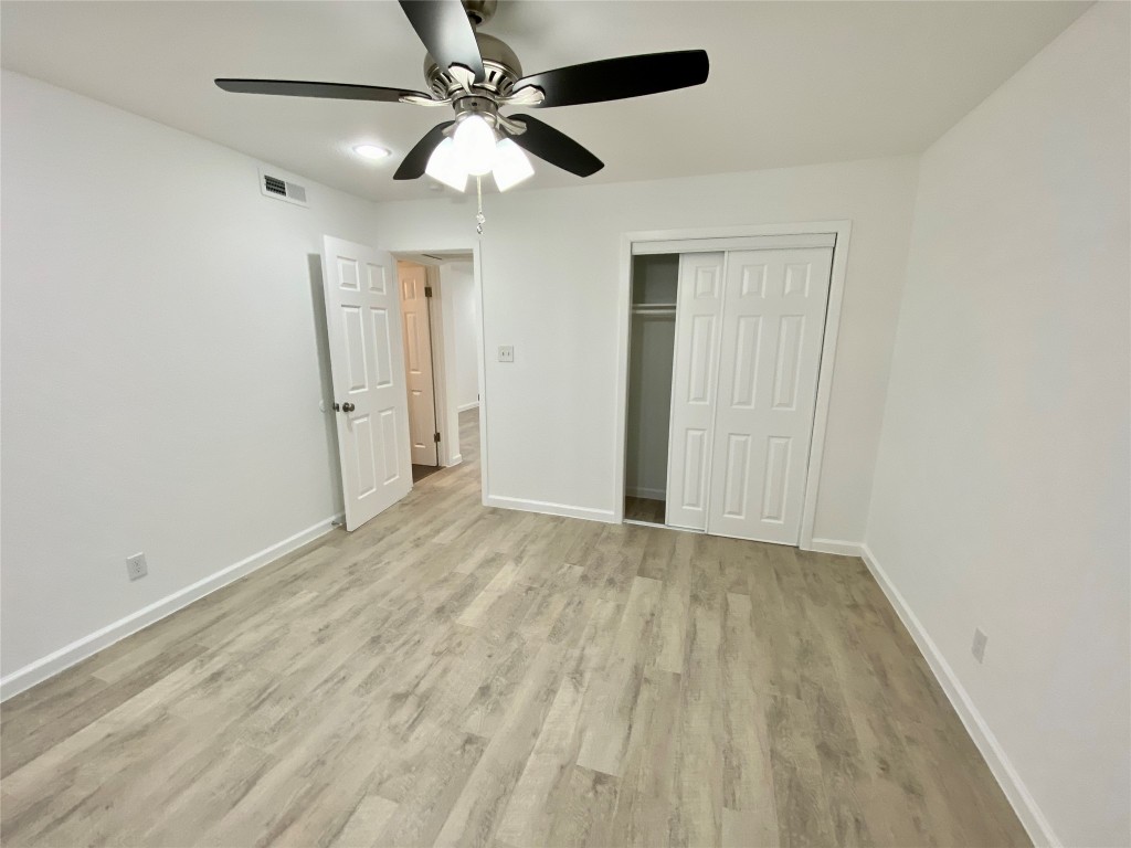 807 Blanco Street, Unit 304 Austin, TX 78703 - Photo 16 of 21 Unfurnished bedroom with a ceiling fan, a closet, and light wood-style floors