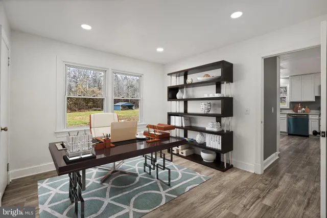 a view of a workspace with furniture and a window