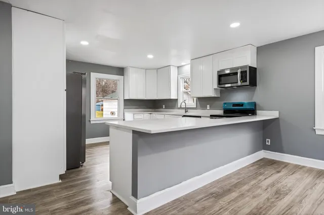 a kitchen with stainless steel appliances granite countertop a refrigerator and a stove top oven