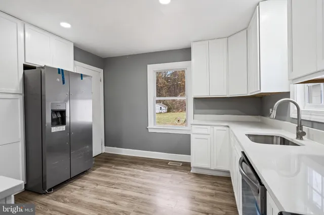 a kitchen with a refrigerator sink and cabinets