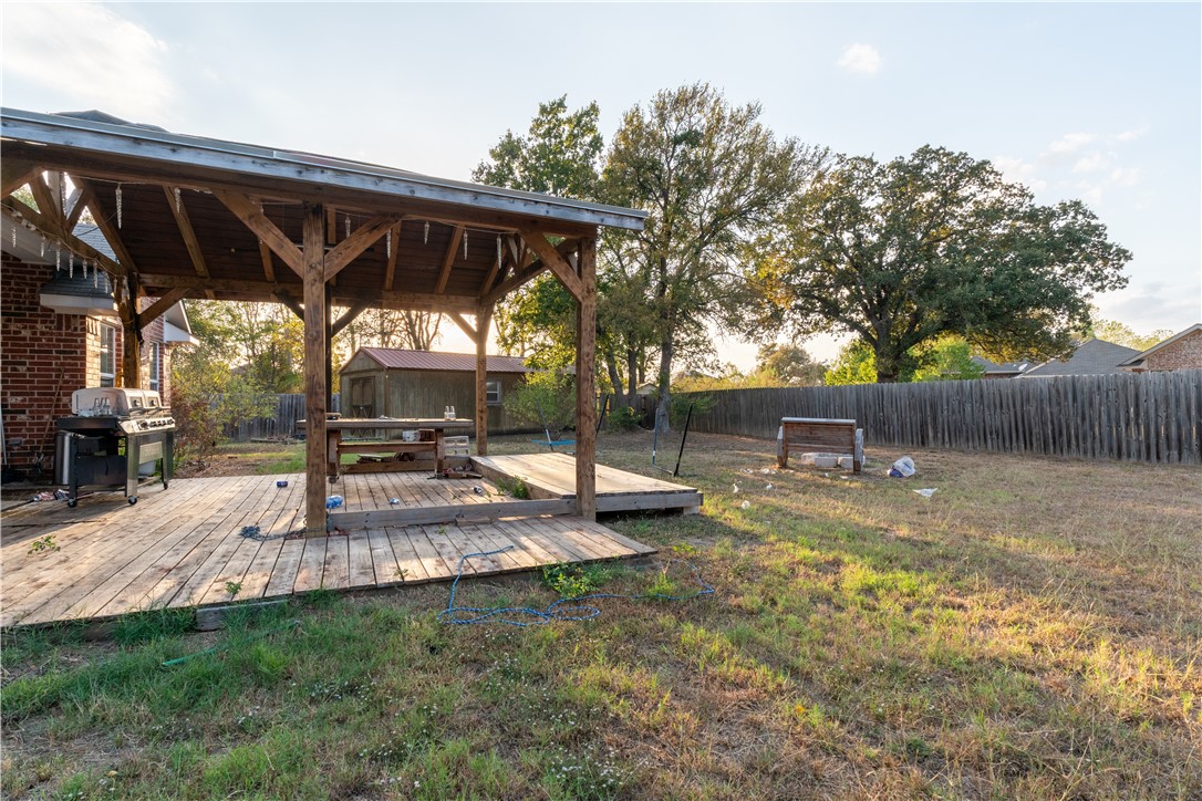 202 Eagle Point Court Waco, TX 76705 - Photo 11 of 14 a view of a backyard with table and chairs under an umbrella with wooden fence