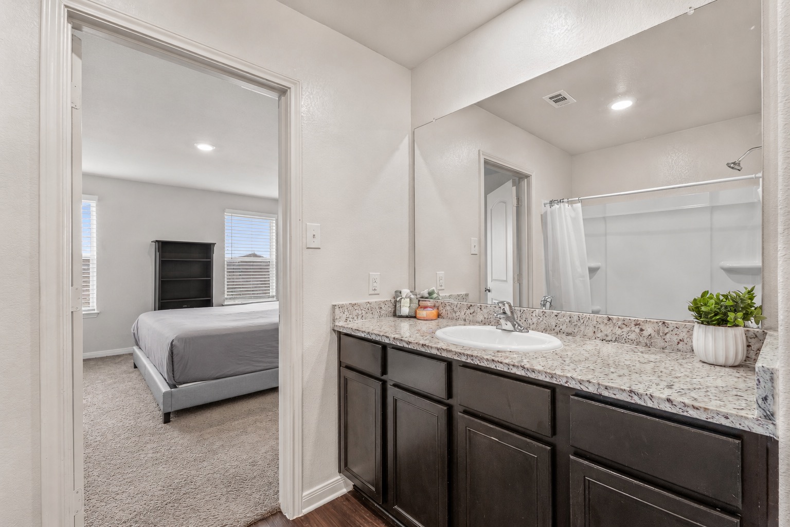 304 Hyacinth Way, Unit #7K Jarrell, TX 76537 - Photo 16 of 26 Marble-look counters and dark cabinetry define this functional bathroom space.