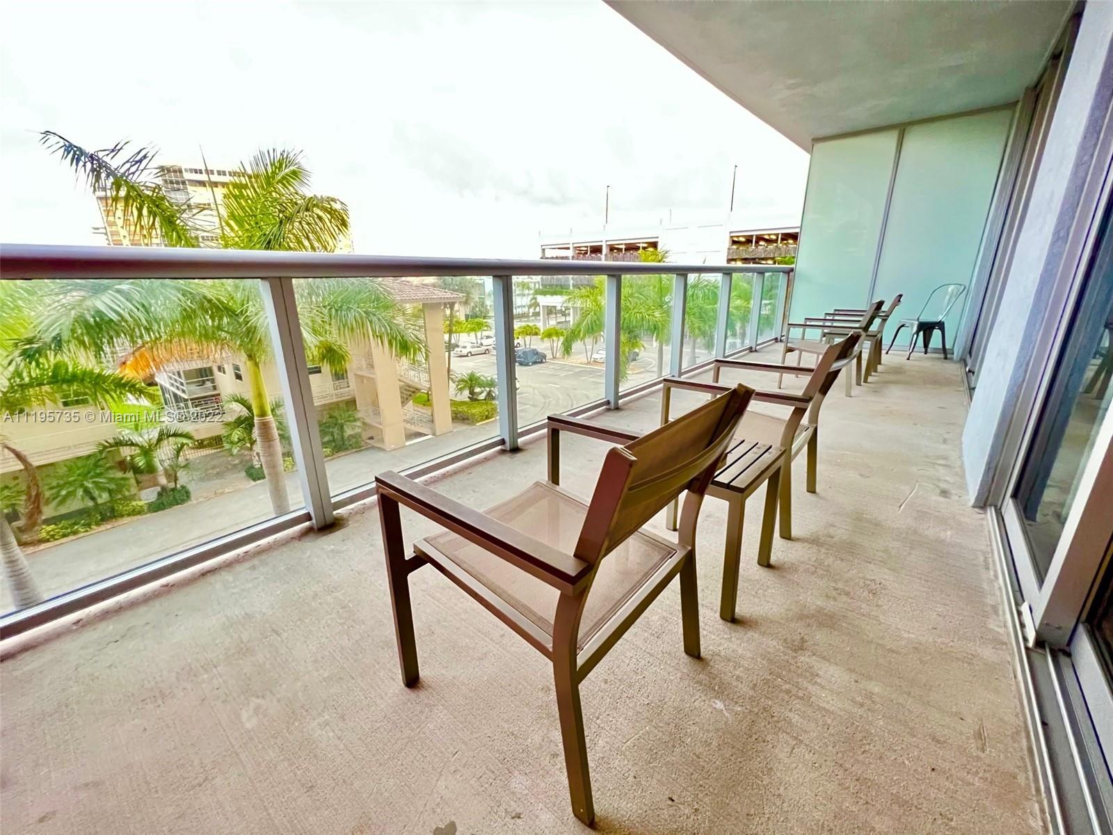 2602 East Hallandale Beach Boulevard, Unit R407 Hallandale Beach, FL 33009 - Photo 21 of 39 a view of a chairs and table in the balcony