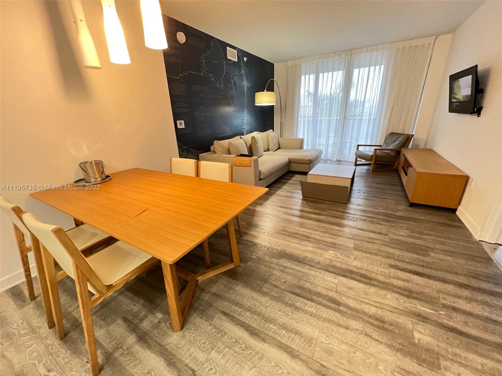 2602 East Hallandale Beach Boulevard, Unit R407 Hallandale Beach, FL 33009 - Photo 23 of 39 a living room with furniture and wooden floor