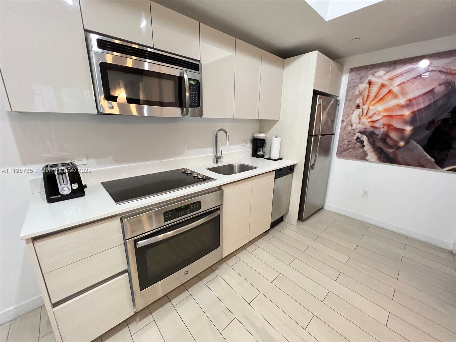 2602 East Hallandale Beach Boulevard, Unit R407 Hallandale Beach, FL 33009 - Photo 27 of 39 a kitchen with stainless steel appliances granite countertop a stove microwave and sink