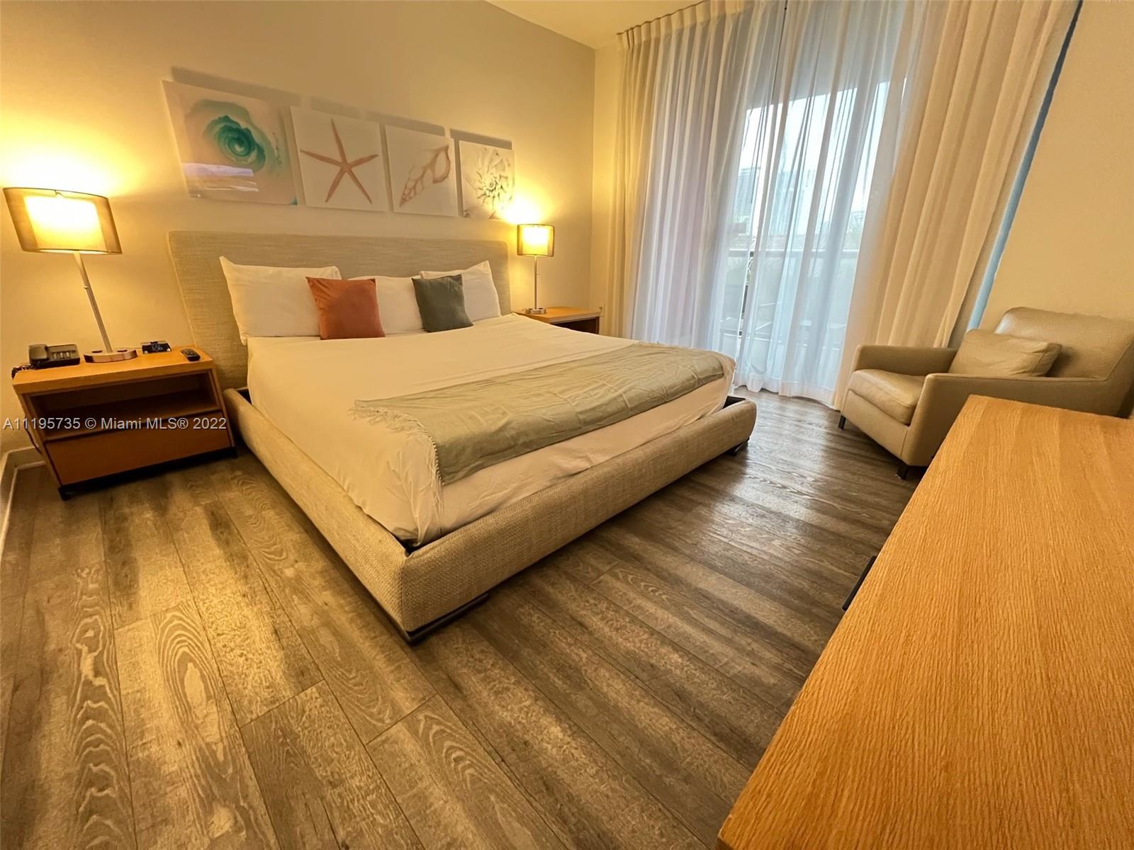 2602 East Hallandale Beach Boulevard, Unit R407 Hallandale Beach, FL 33009 - Photo 28 of 39 a bedroom with a bed and wooden floor