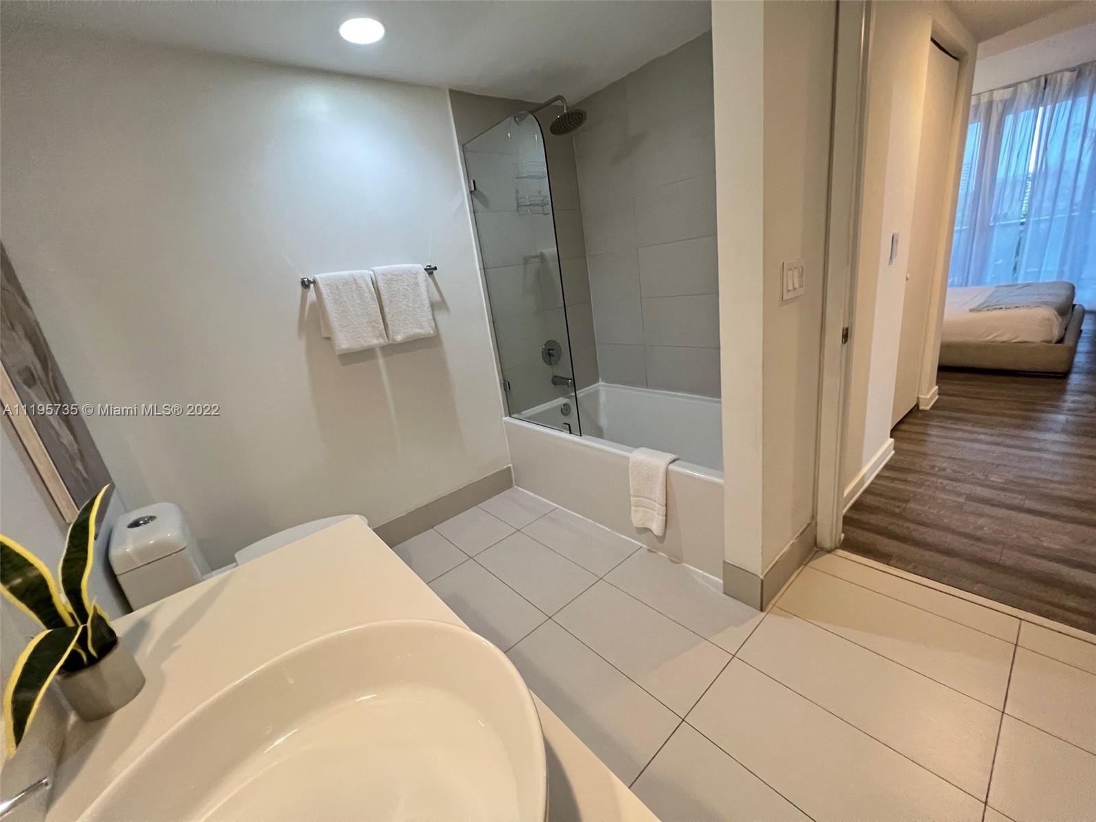2602 East Hallandale Beach Boulevard, Unit R407 Hallandale Beach, FL 33009 - Photo 30 of 39 a bedroom with a bed and a view of living room