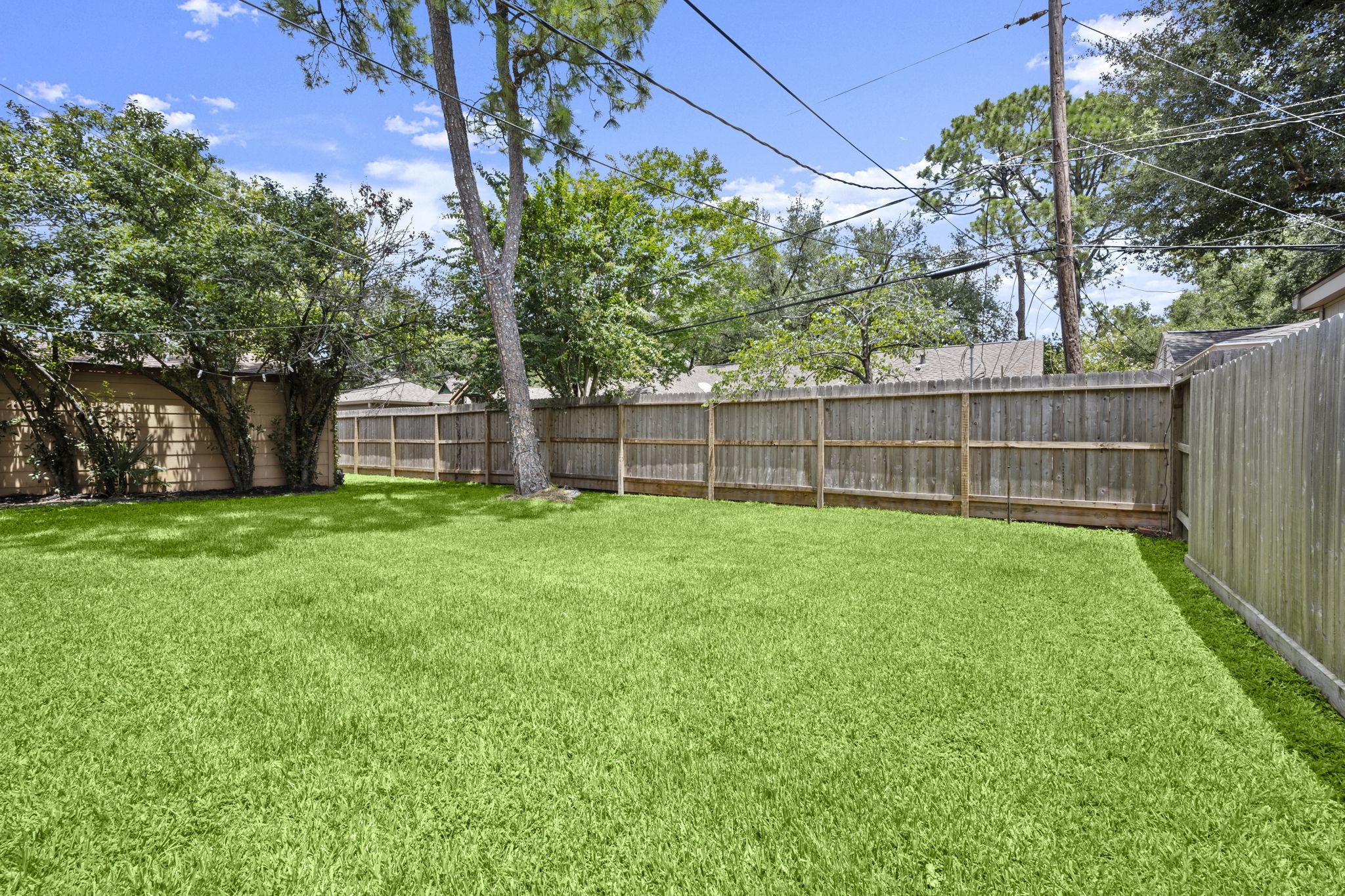 2506 Teague Road Houston, TX 77080 - Photo 32 of 33 a view of a yard with a large tree and wooden fence